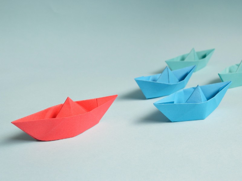 Four origami paper boats in a line